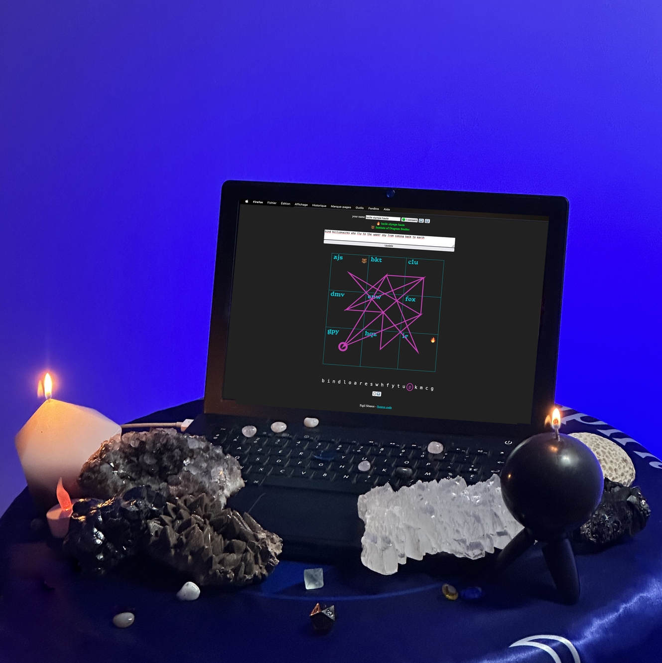 studio photograph of a laptop surrounded by candles and crystals of various sizes, the screen shows the sigil séance web application